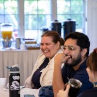 Group of GVSU Alumni smile while they sit at table together